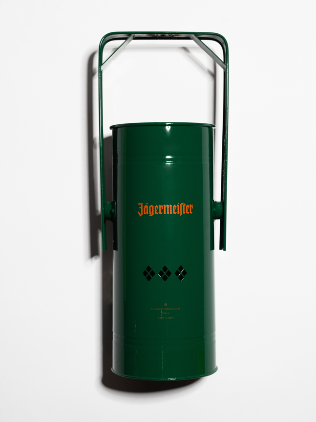 Green metal incense burner with handle and orange Jägermeister logo on a white background