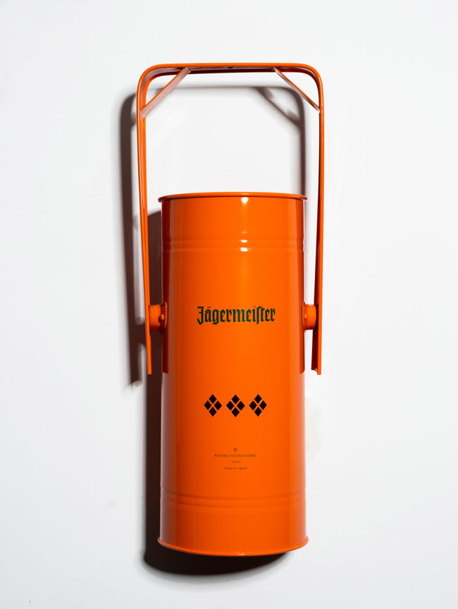Orange metal incense burner with handle and green Jägermeister logo on a white background