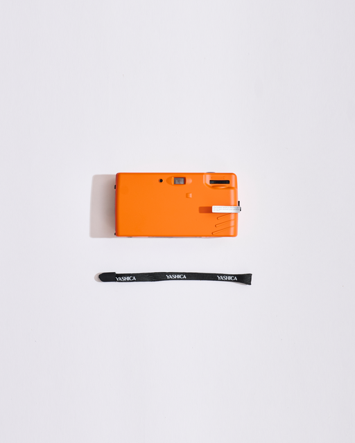 Orange camera with a strap on a white background