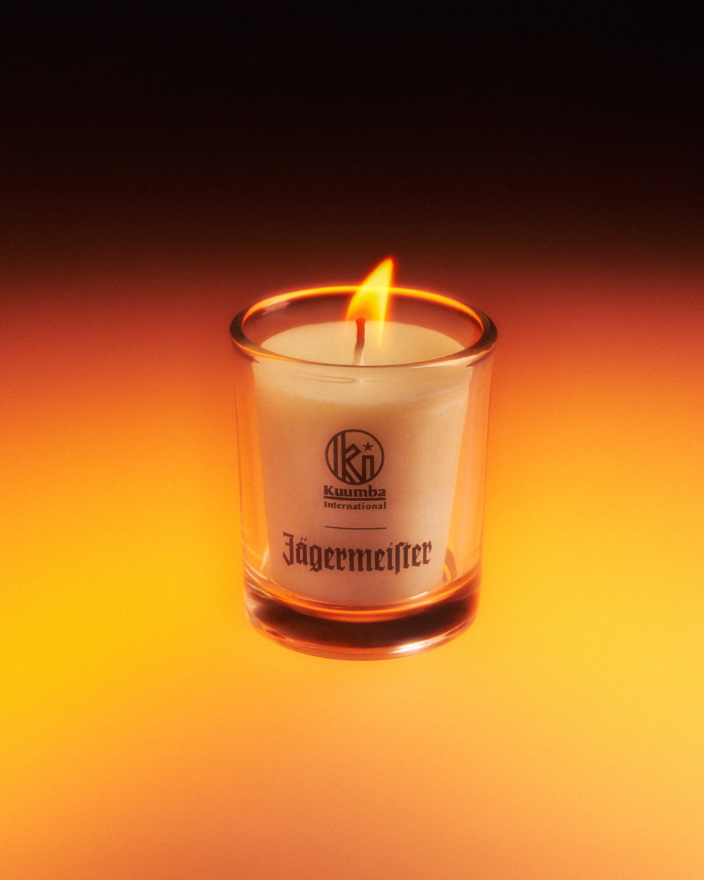 Jagermeister candle in a glass container with a dark background