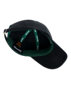 Gorra negra con interior verde y el logotipo de la marca Jägermeister visible.