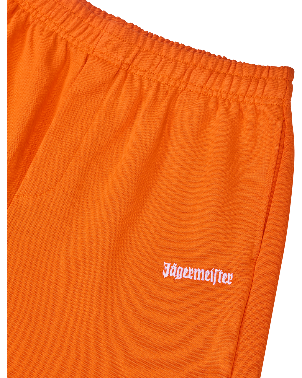Close-up of orange pants with white Jägermeister logo.