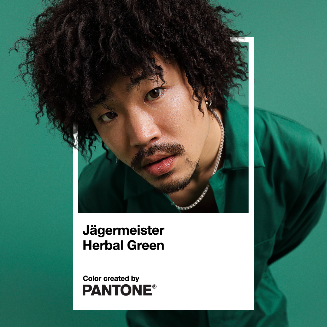 A Pantone Color card for 'Jägermeister Herbal Green' featuring a portrait of a man with curly hair wearing a green shirt against a solid green background.